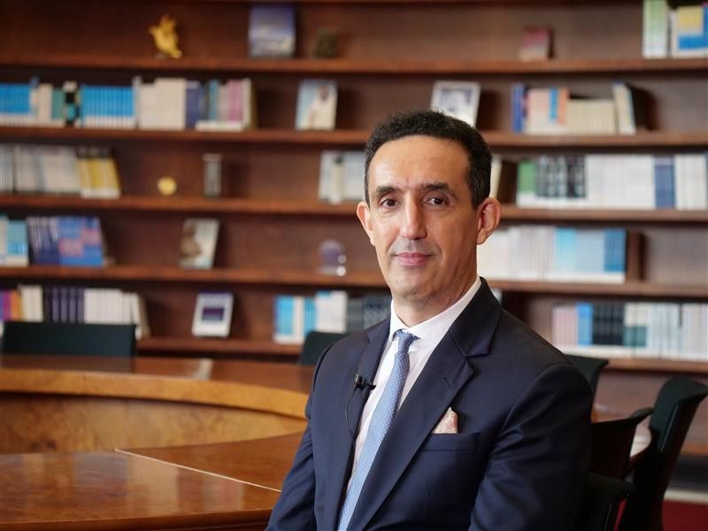 Nabil Zary seated in front of a library.